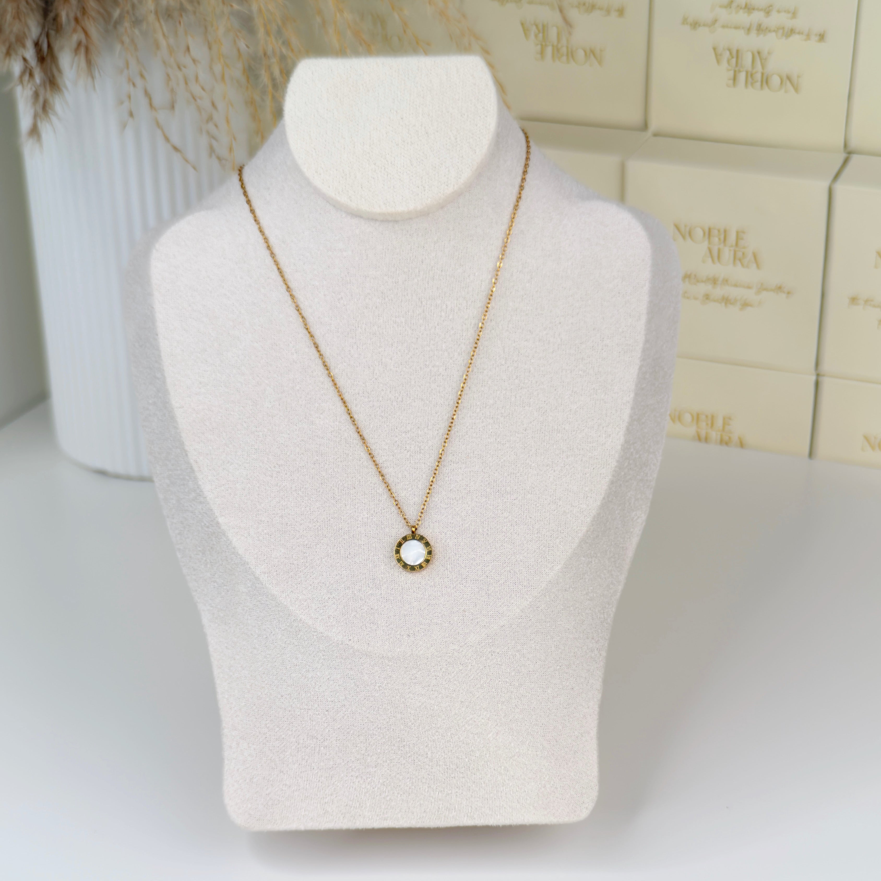 Gold Roman numeral pendant necklace with elegant detailing by Noble Aura UK. Comes in Premium packaging. Free Delivery over £50.