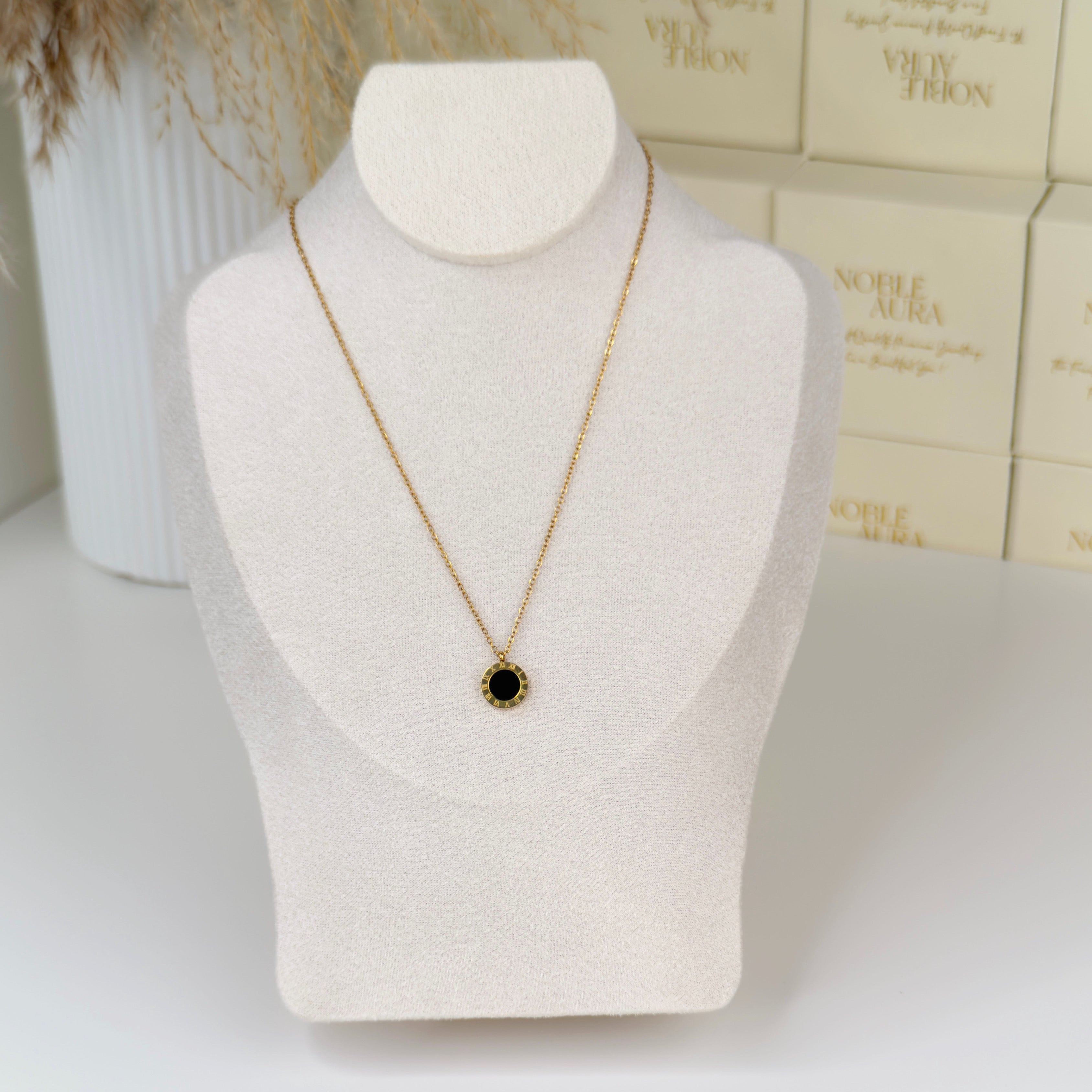 Gold Roman numeral pendant necklace with elegant detailing by Noble Aura UK. Comes in Premium packaging. Free Delivery over £50.