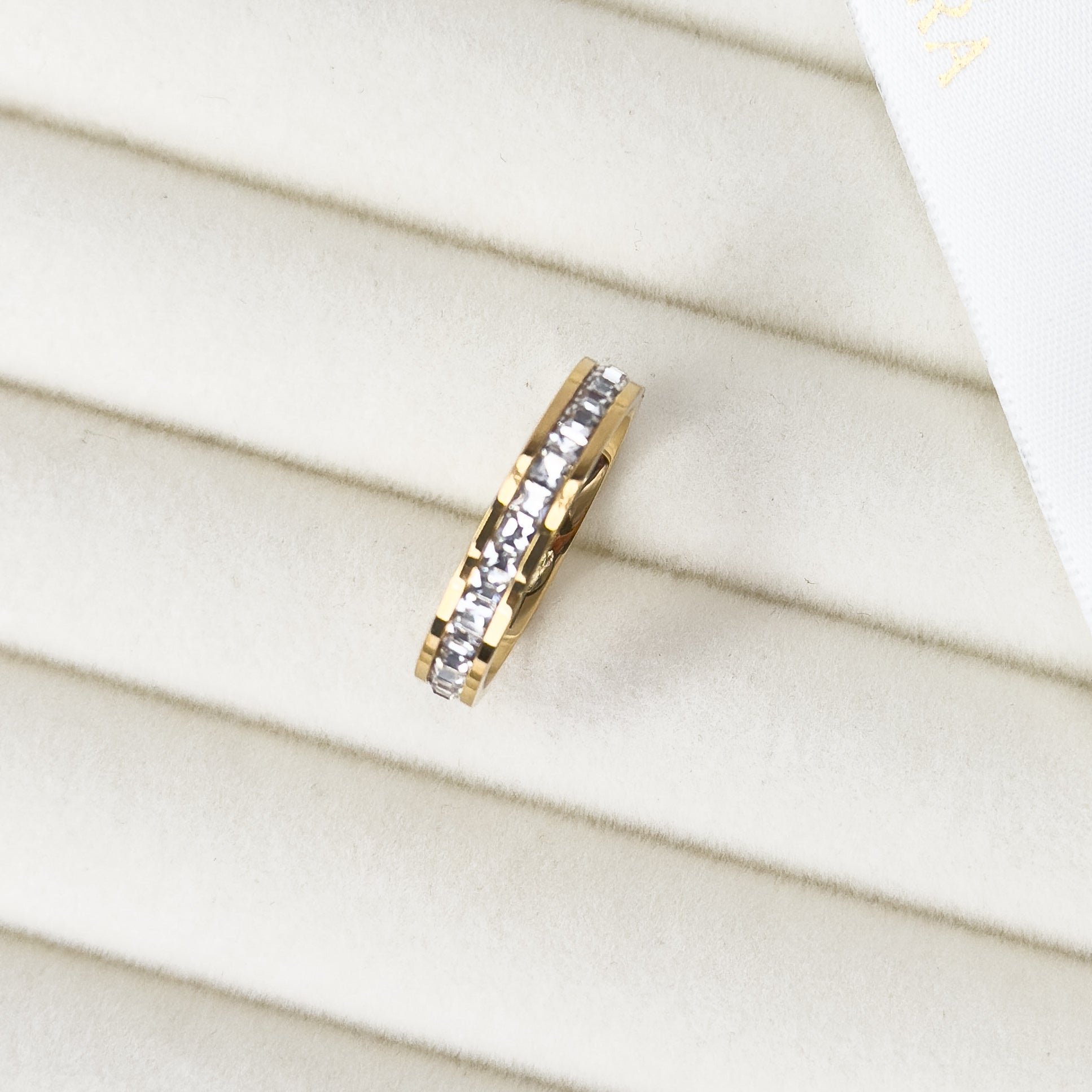 Gold eternity band ring with continuous stone detailing by Noble Aura UK

