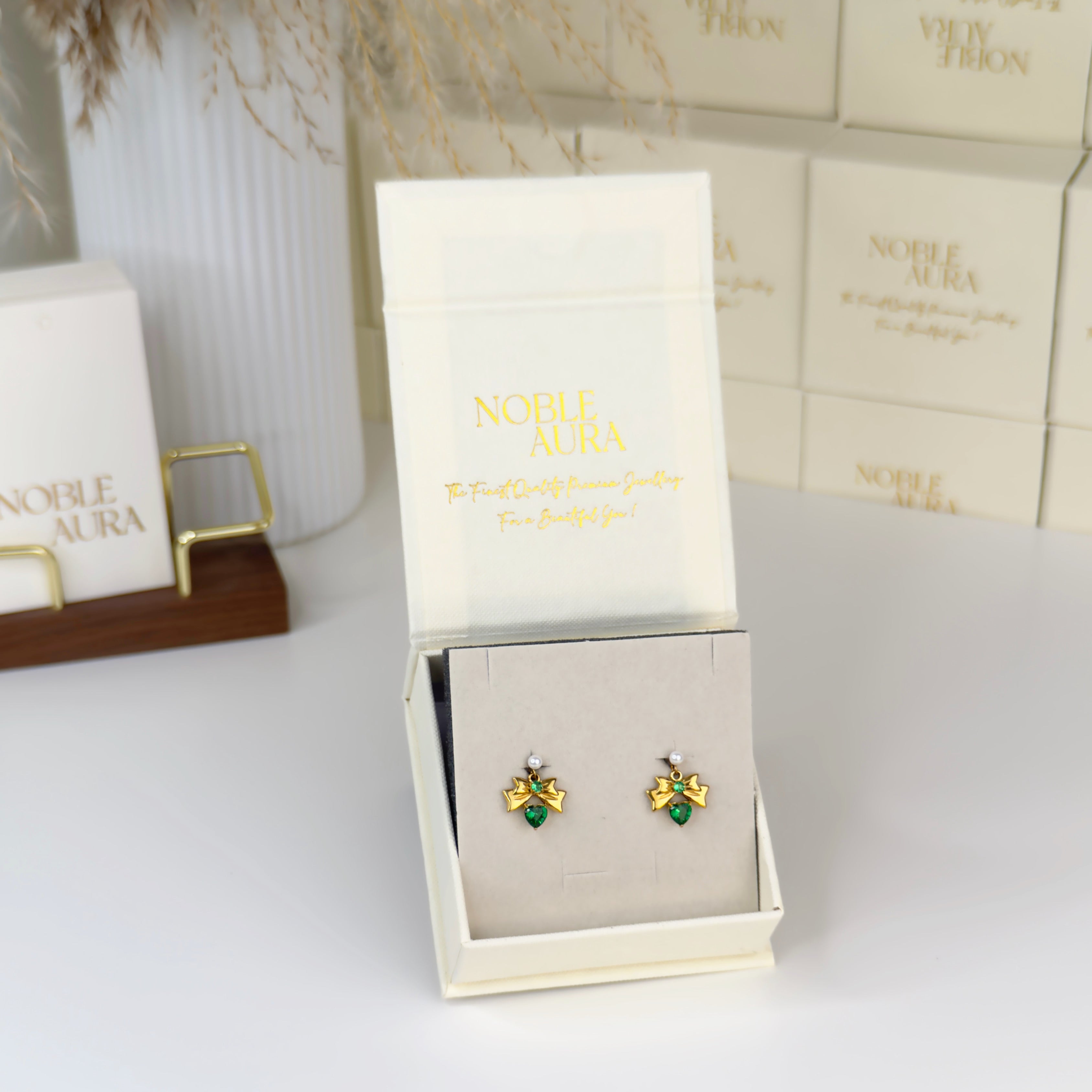 Emerald bow heart drop earrings with pearl stud detail by Noble Aura UK