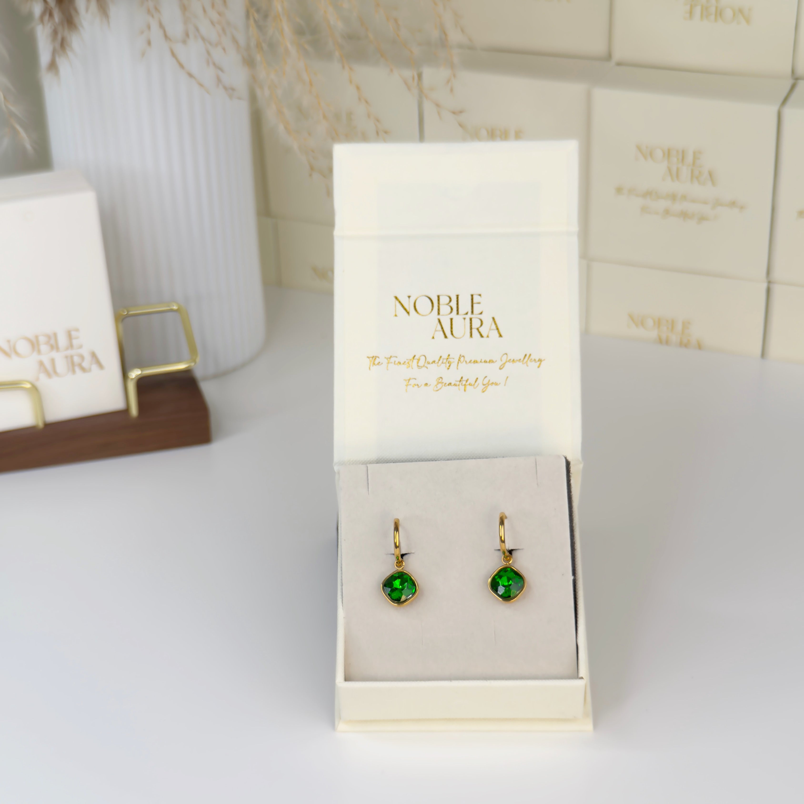 Gold earrings with emerald green crystal detailing by Noble Aura UK

