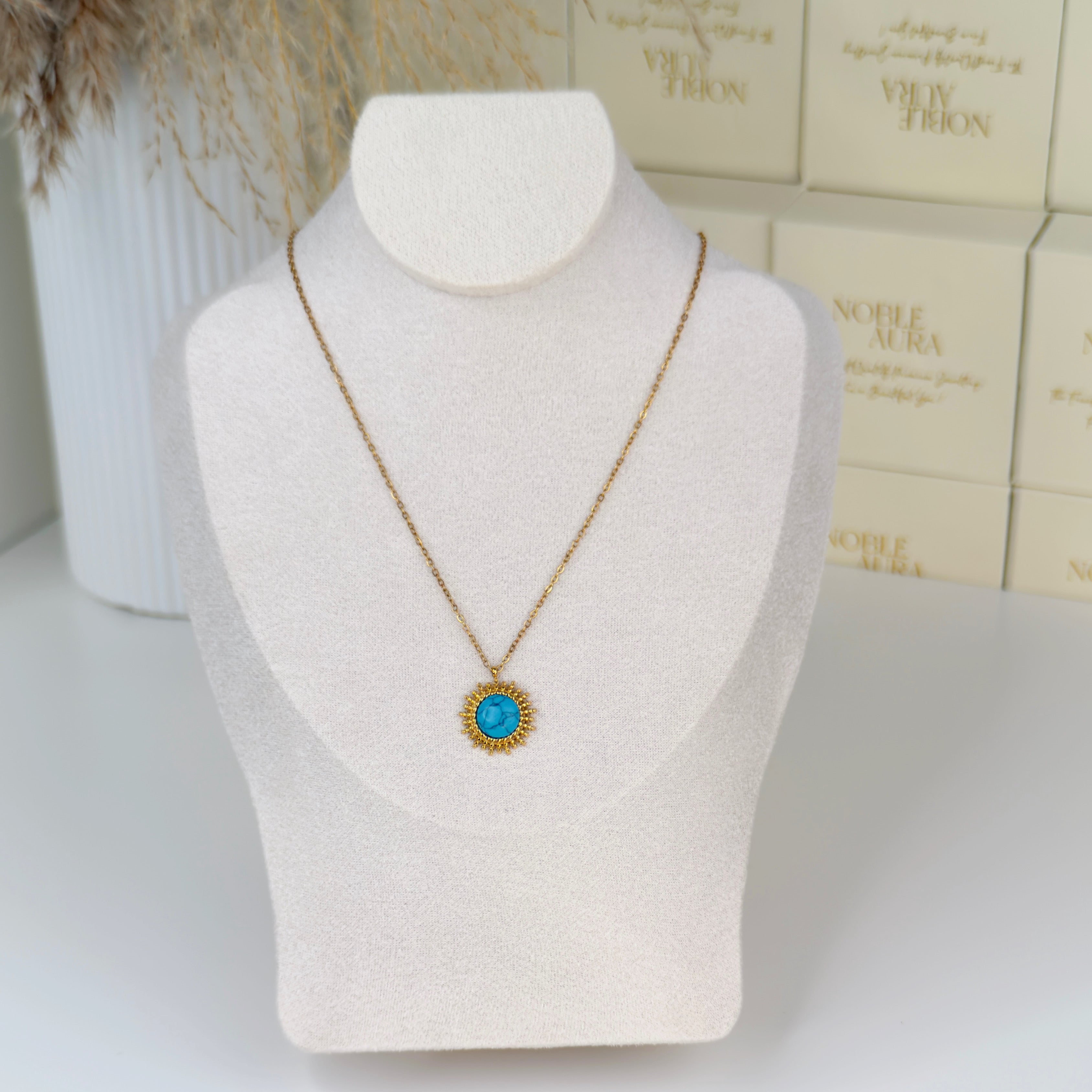 Gold sunburst pendant necklace with turquoise stone centre by Noble Aura UK
